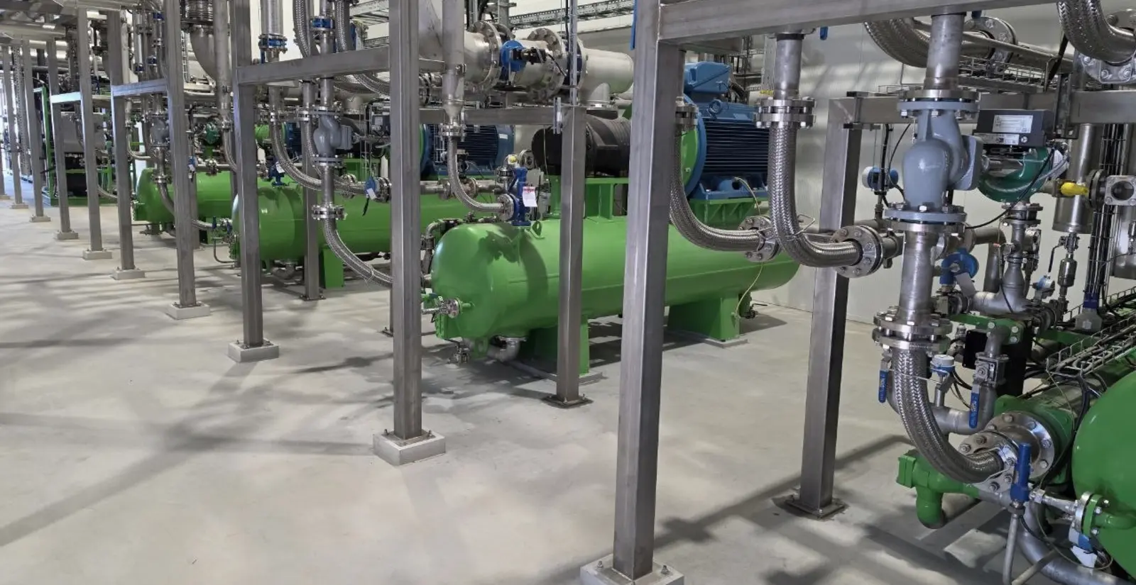 Gegoten machinevoeten en leidingwerk in een procesruimte